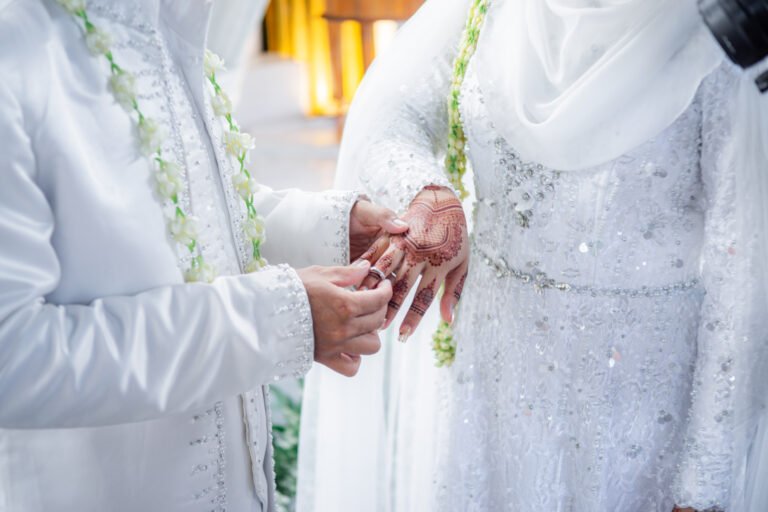 Bride and groom exchanging rings during a traditional Indonesian wedding ceremony, symbolizing their commitment and love. Asian muslim wedding
