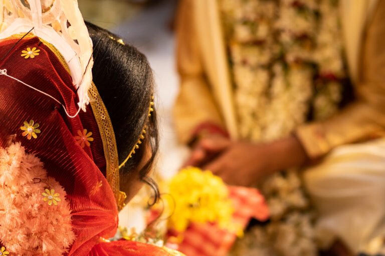 Hindu traditional marriage rites being performed with bride and groom sitting together in presence of priest. Bride in red saree. Symbolic photo of hindu religious culture  of wedding ceremony.